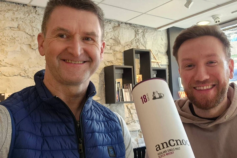 Hamish Malcolm of The Dram Caddy and Simon Fraser of The Business Partnership celebrate with a bottle of anCnoc Highland Single Malt Scotch Whisky, a successful digital project supported by Inverness web design specialists MacKenzie Business Solutions.